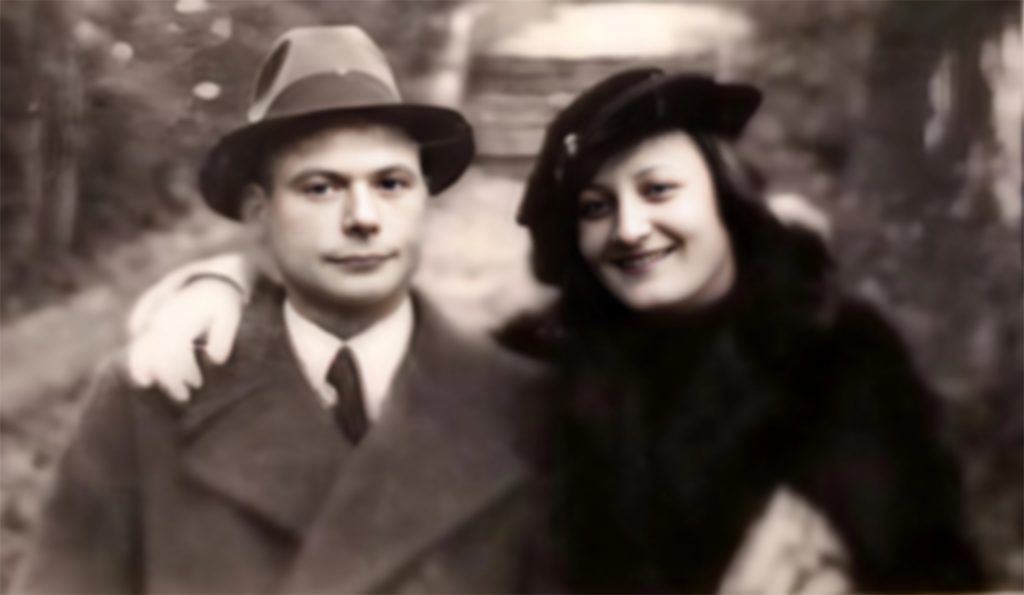 Ein Schwarz-Weiß-Foto eines Mannes in Anzug und Hut, der neben einer lächelnden Frau in Mantel und Hut steht, die ihren Arm um seine Schulter legt. Sie stehen im Freien auf einem Weg und symbolisieren den unterstützenden Geist von Über uns Raphaelswerk.